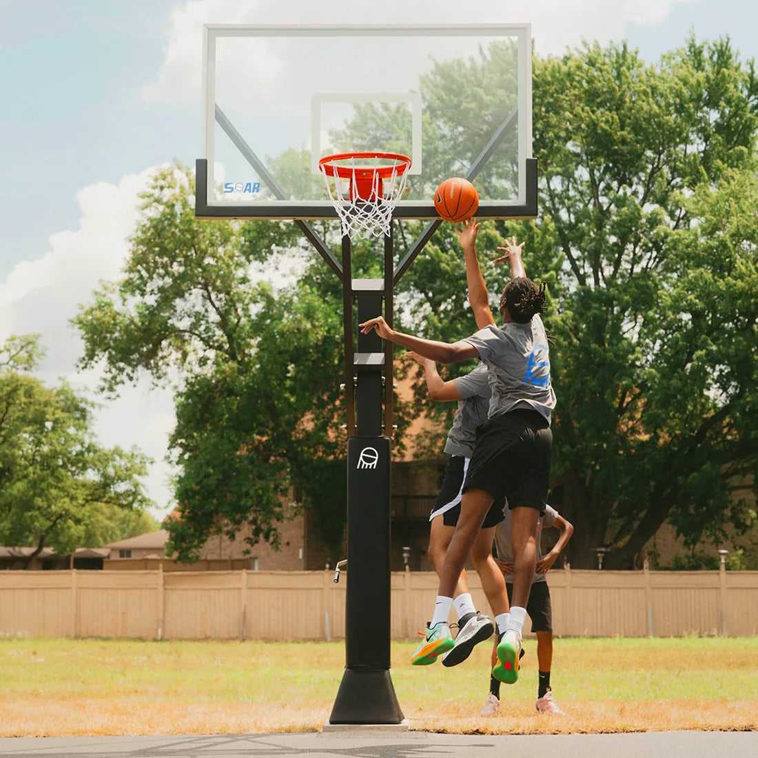 Players going up for a basket on a SOAR basketball hoop outdoors