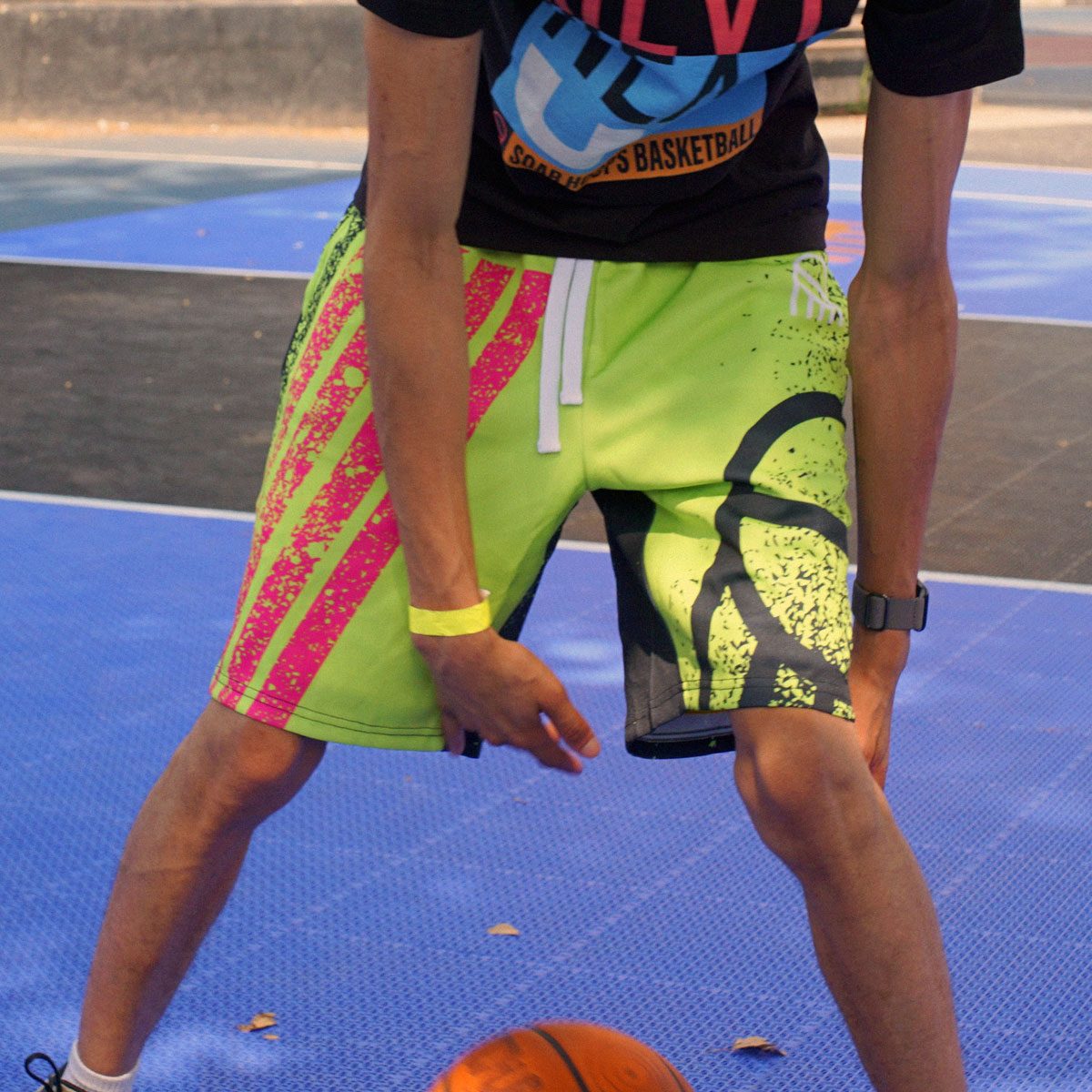 Fresh Paint shorts in neon green and pink, worn in a defensive stance