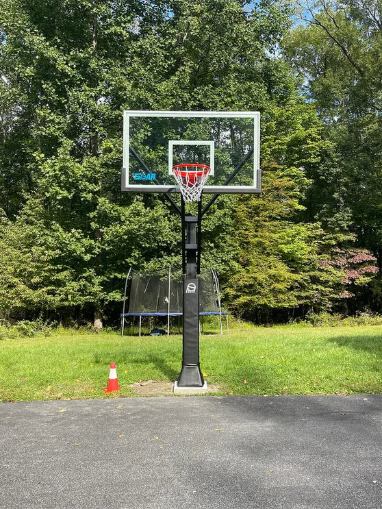 SOAR basketball hoop on a driveway surrounded by trees