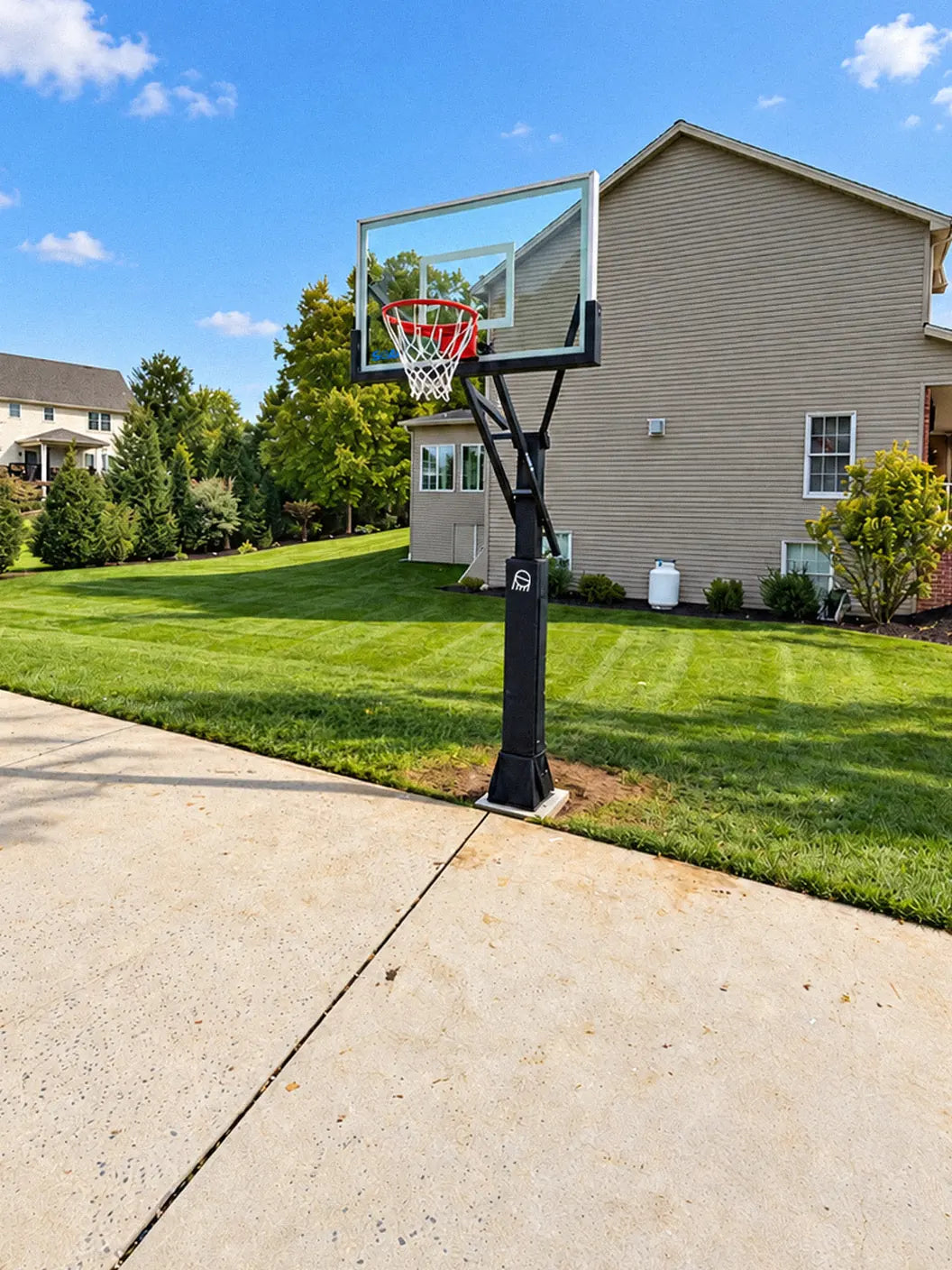 SOAR basketball hoop on a driveway beside a suburban house