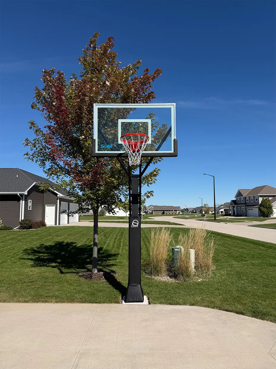 SOAR basketball hoop beside a suburban street under a blue sky